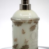 ORY Two-Tone Leaf botanical glass lotion bottle featuring layered cream and translucent glass, soft leaf and butterfly illustrations, and a brushed silver pump for personalized skincare.