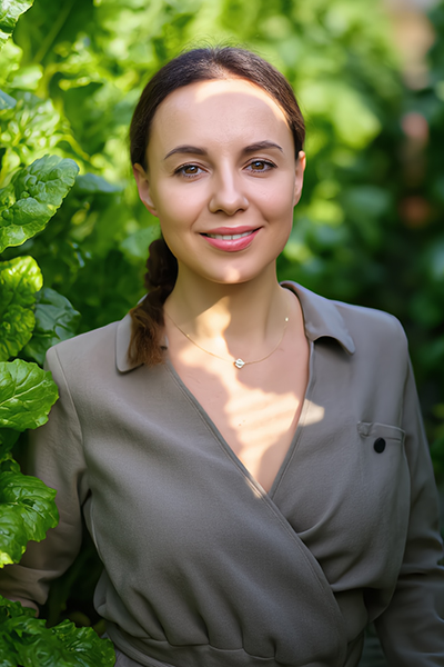 Woman standing among lush green leaves — natural beetroot extract and botanical skincare inspiration by ORY Skincare.
