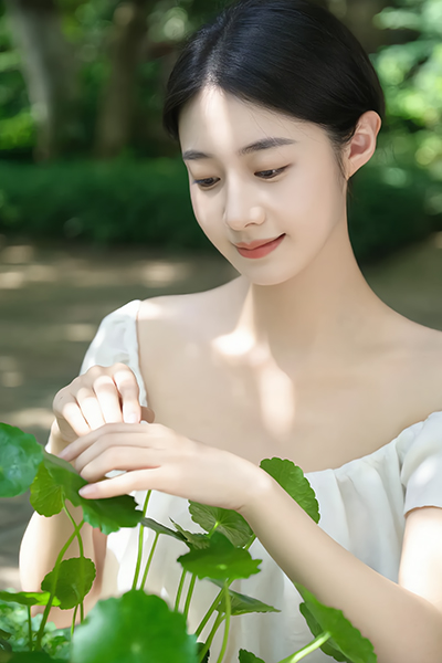 Woman gently touching Centella Asiatica leaves in a garden — soothing cica extract used in ORY Skincare.