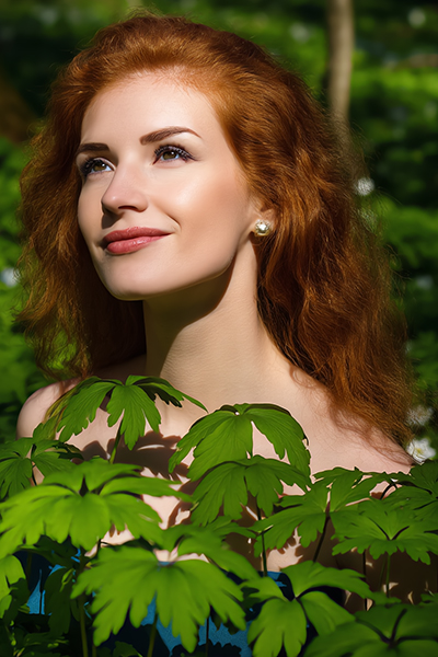 Woman with smooth, hydrated skin framed by green foliage, representing urea’s moisture-binding and skin-softening benefits in advanced skincare formulations.