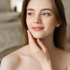 Woman with smooth, balanced complexion applying hydrating lotion — ORY Skincare moisturizer for normal skin.