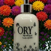 Elegant personalized ORY botanical infused hand and body lotion bottle with pump dispenser, featuring leaf and butterfly designs on floral background, showcasing Oryskincare's custom natural skincare solutions for nourished, hydrated skin.