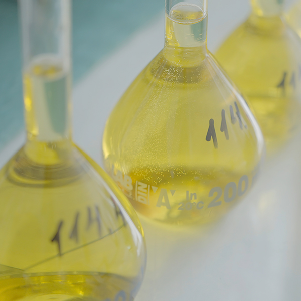 Laboratory glass flasks filled with golden botanical-infused oil, representing ORY Skincare’s controlled botanical infusion process focused on purity, safety, and formulation accuracy.