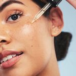 Close-up of woman applying facial oil with dropper — hydrating botanical serum by ORY Skincare.