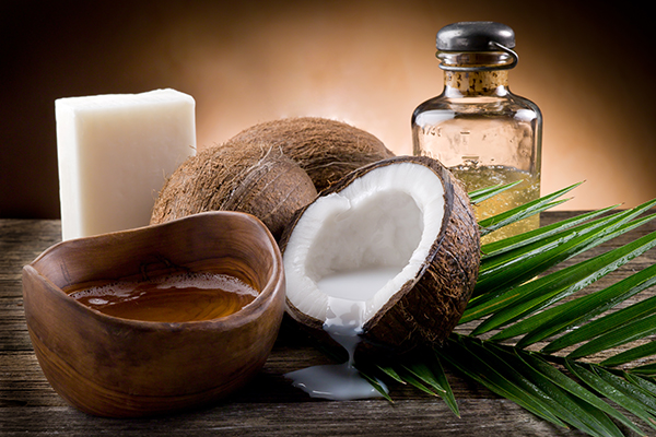Coconut oil with fresh coconuts, palm leaves, and wooden bowl — natural hydrating coconut oil for ORY Skincare.