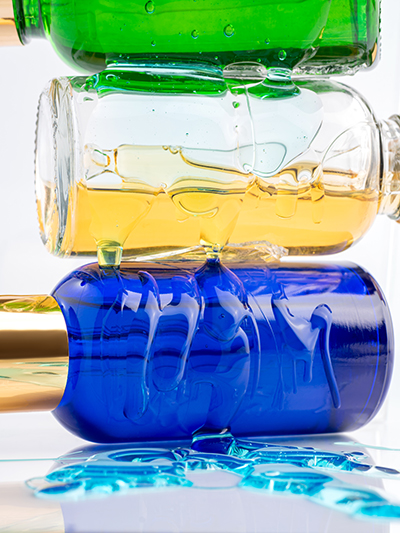 Layered glass bottles containing oil and water phases, visually illustrating emulsifier science and the interaction of ingredients in ORY Skincare formulations.