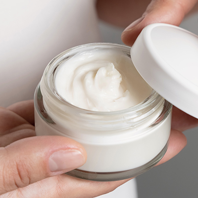 Creamy skincare emulsion in an open glass jar, showcasing smooth stabilized texture created through emulsifier science in ORY Skincare formulations.