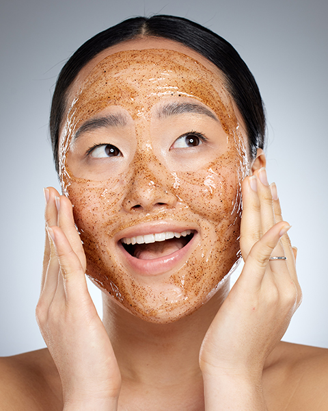 Woman applying a natural face scrub with botanical exfoliants, demonstrating ORY Skincare’s gentle exfoliation step in a complete skincare routine.