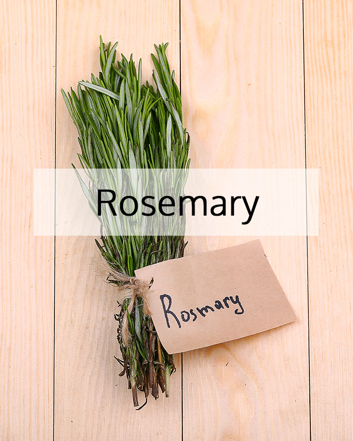 Fresh rosemary sprigs bundled on a light wooden surface with a handwritten label, representing the aromatic botanical used in ORY Skincare formulations.