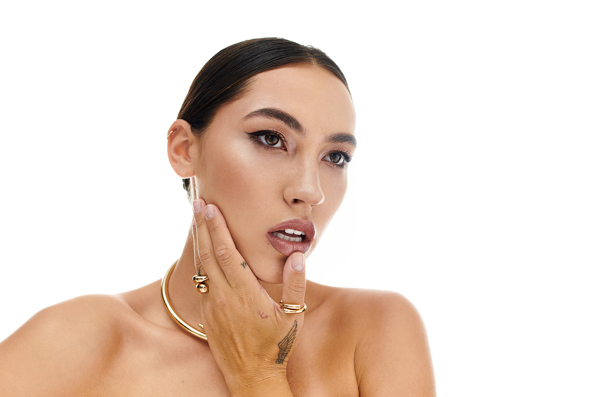 Woman with smooth, luminous dry skin touching her face, representing ORY Skincare solutions for dry skin hydration, nourishment, and barrier support.