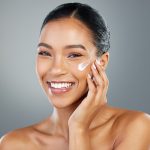Woman applying moisturizer to her face, representing ORY Skincare build your own lotion customized for hydration, nourishment, and healthy skin.