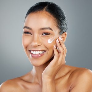 Woman applying moisturizer to her face, representing ORY Skincare build your own lotion customized for hydration, nourishment, and healthy skin.
