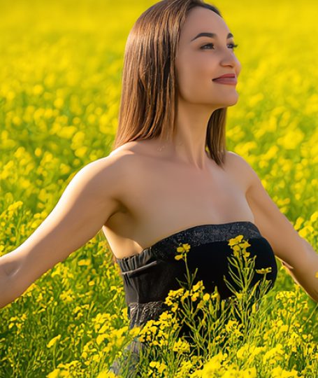 Woman in a bright yellow field at sunset — plant-derived behenyl alcohol skincare ingredient used by ORY Skincare.