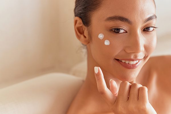 Woman applying facial cream with a gentle touch, showcasing a hydrating botanical skincare routine by ORY Skincare.